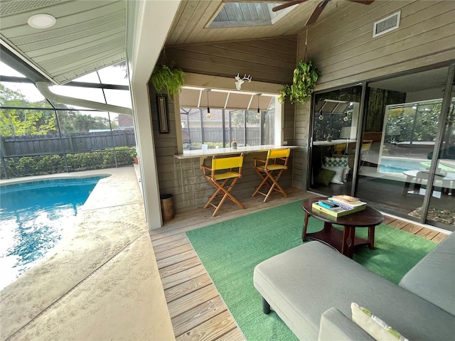 view of swimming pool featuring ceiling fan, a lanai, fence, outdoor dry bar, and a fenced in pool