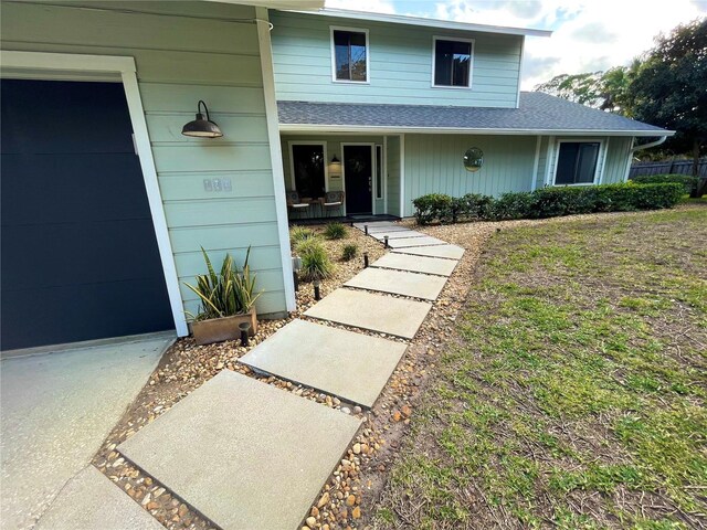 exterior space with a garage and a shingled roof