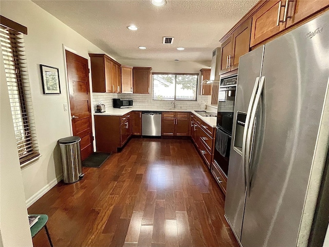 kitchen featuring tasteful backsplash, visible vents, appliances with stainless steel finishes, dark wood-style flooring, and light countertops