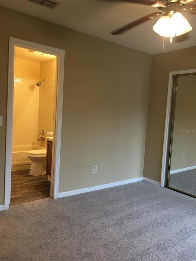 unfurnished bedroom featuring carpet, connected bathroom, and ceiling fan