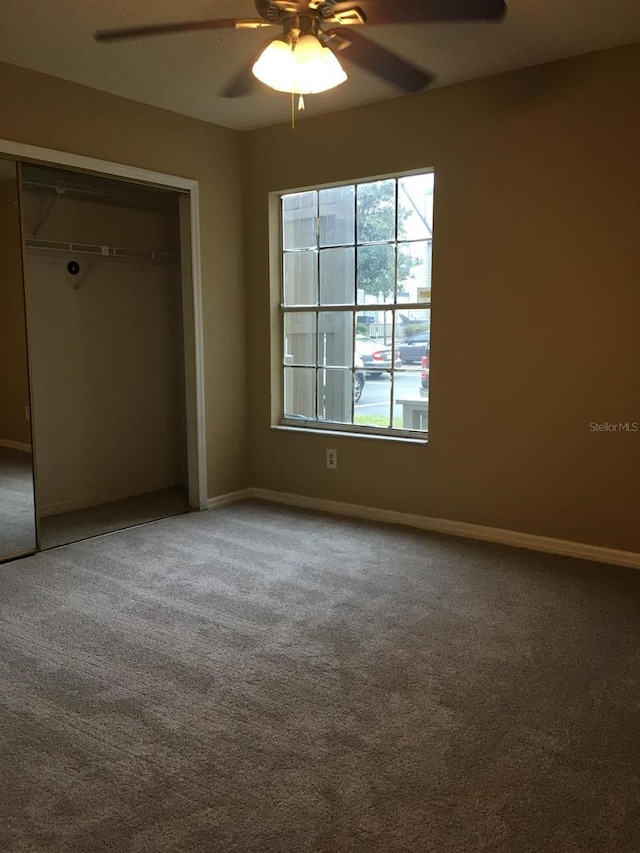 unfurnished bedroom with carpet, a closet, and ceiling fan