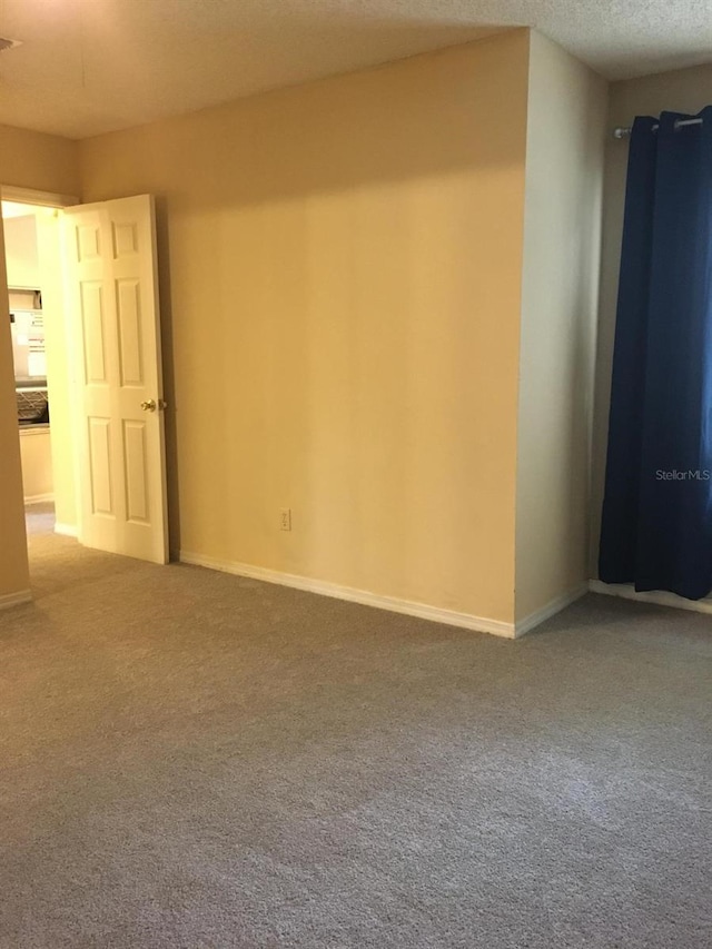 carpeted spare room featuring a textured ceiling