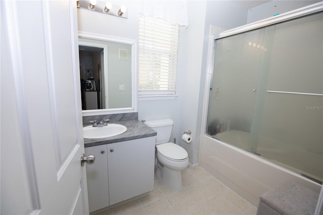 full bathroom with toilet, vanity, bath / shower combo with glass door, and tile patterned flooring