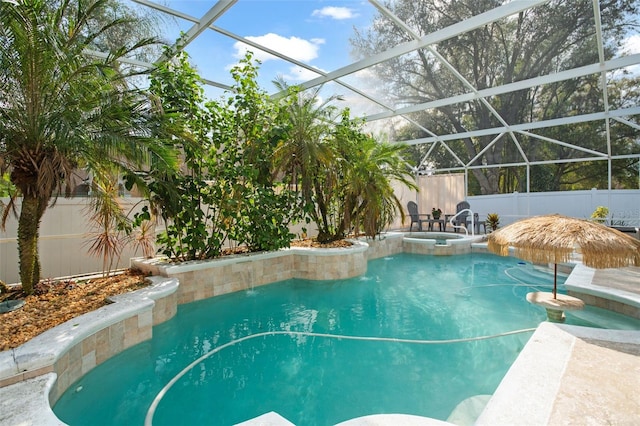 view of swimming pool with an in ground hot tub, pool water feature, and glass enclosure