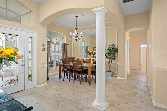 dining room featuring light tile patterned floors, ornamental molding, decorative columns, and a chandelier