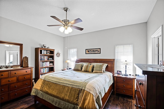 bedroom with multiple windows, dark hardwood / wood-style floors, and ceiling fan