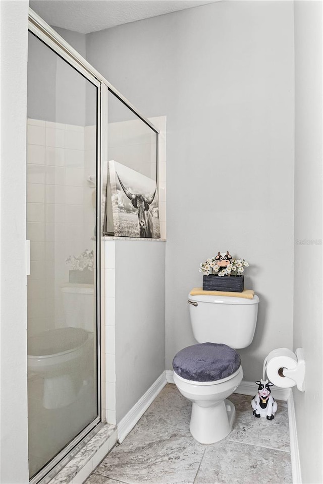 bathroom with a shower with door and toilet