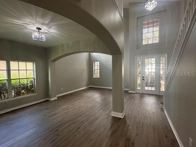 entryway with a chandelier, arched walkways, and plenty of natural light