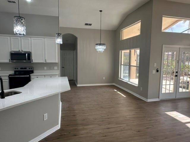 kitchen featuring black range with electric cooktop, visible vents, white cabinets, light countertops, and stainless steel microwave