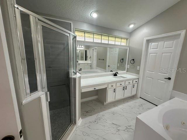 full bathroom featuring a textured ceiling, vanity, marble finish floor, a jetted tub, and a stall shower