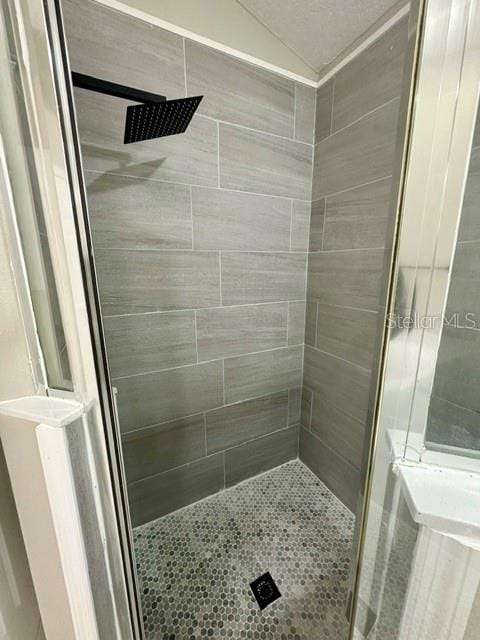 bathroom featuring a stall shower and vaulted ceiling