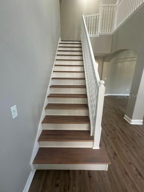 stairway featuring baseboards and wood finished floors