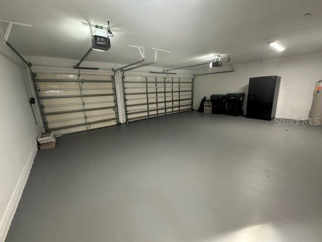 garage with baseboards and a garage door opener