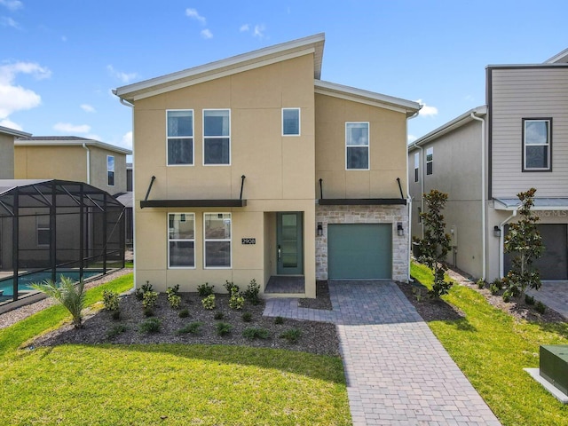 view of front of home featuring a garage, a lanai, and a front lawn