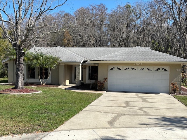 ranch-style home with a garage and a front lawn