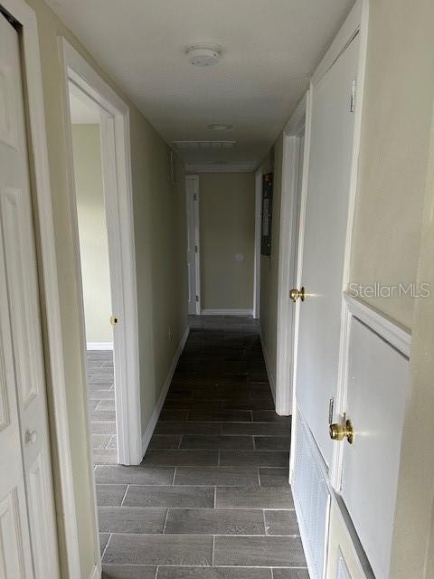 corridor featuring wood finish floors and baseboards