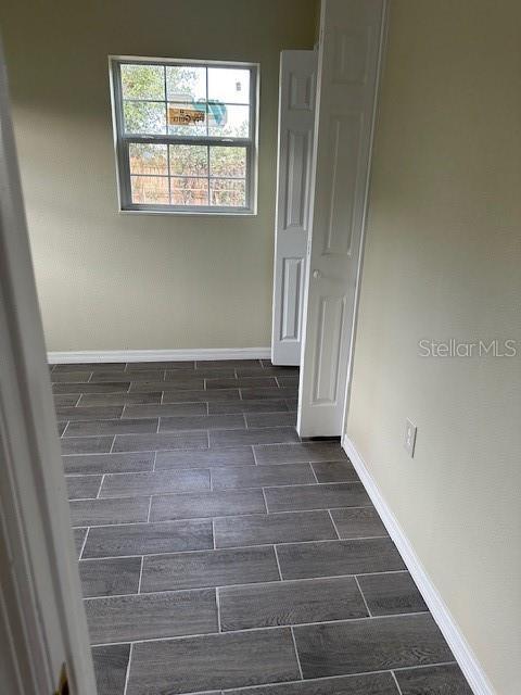 spare room with wood finish floors and baseboards