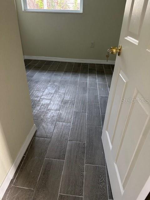 interior space with dark wood-style floors, plenty of natural light, and baseboards