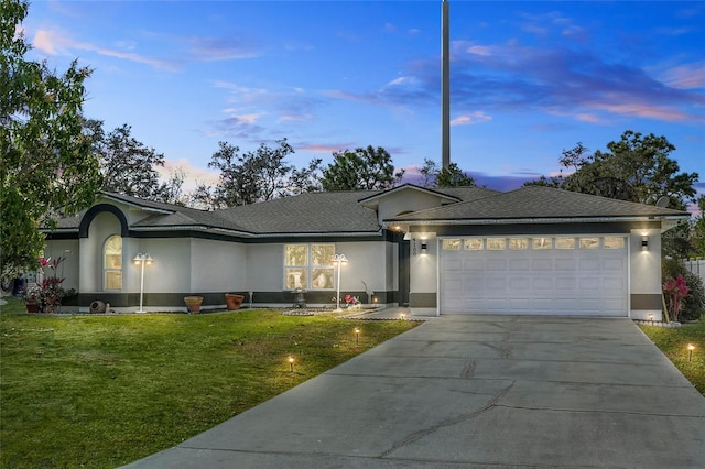 single story home featuring concrete driveway, a yard, and stucco siding