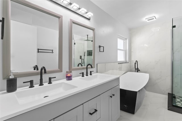 bathroom with marble finish floor, a sink, a freestanding bath, and double vanity