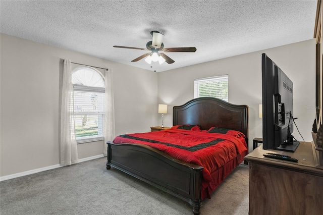 bedroom featuring light carpet, ceiling fan, baseboards, and a textured ceiling