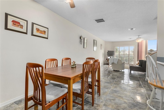 dining space featuring a textured ceiling and ceiling fan