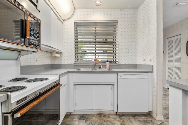 kitchen featuring sink, white appliances, and white cabinets