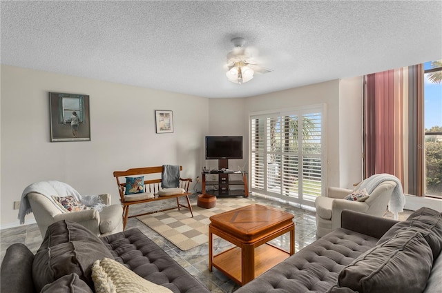 living room with a textured ceiling and ceiling fan