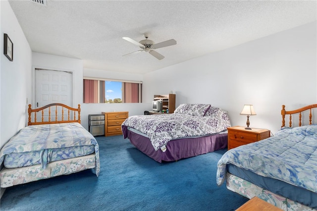 carpeted bedroom featuring ceiling fan and a textured ceiling