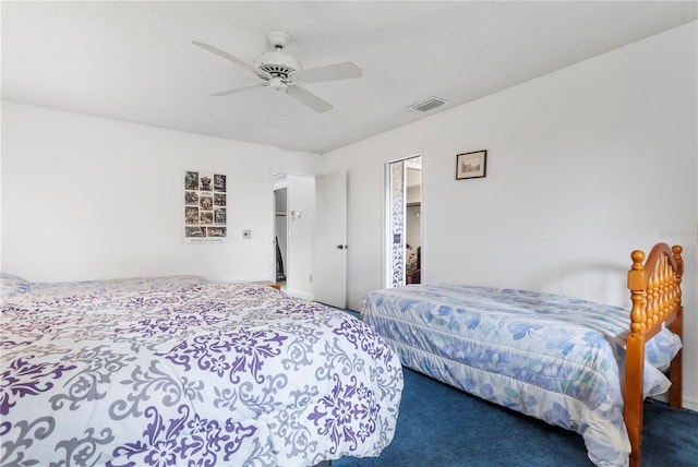 carpeted bedroom featuring ceiling fan and a textured ceiling