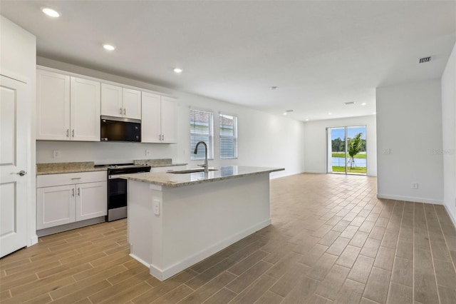 kitchen with visible vents, a sink, light wood-style floors, light stone countertops, and stainless steel electric range oven