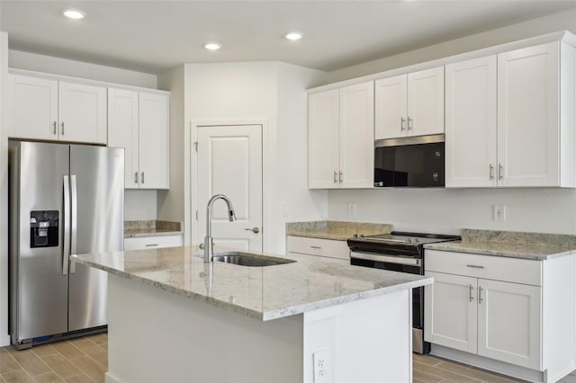 kitchen with wood tiled floor, appliances with stainless steel finishes, white cabinetry, and a sink