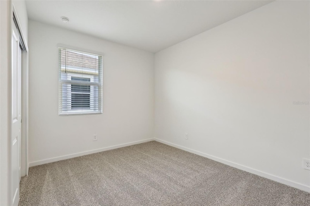 unfurnished bedroom with baseboards, carpet flooring, and a closet