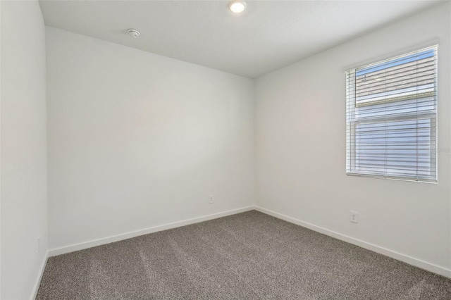 unfurnished room featuring carpet floors and baseboards