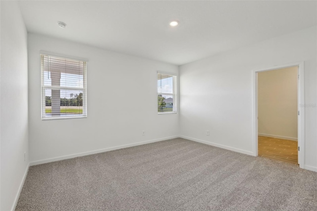 carpeted empty room with baseboards and recessed lighting