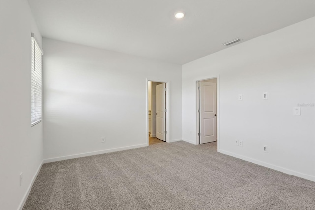 unfurnished room featuring recessed lighting, light carpet, visible vents, and baseboards