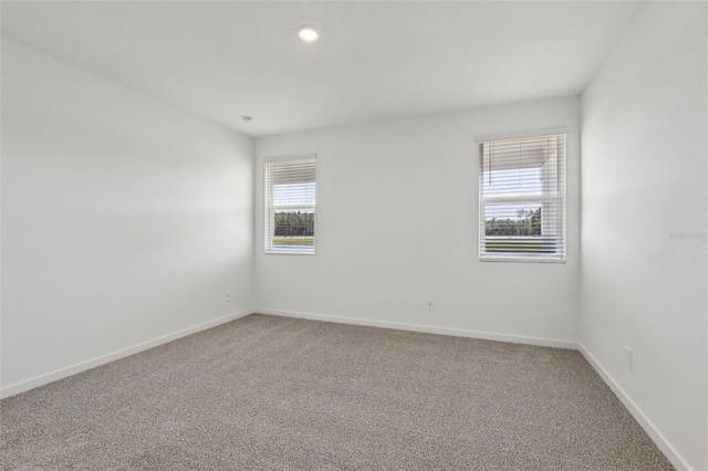 empty room with baseboards, carpet, and recessed lighting