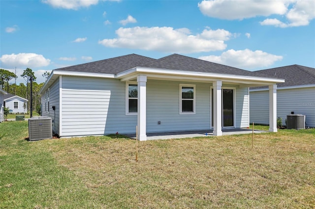 rear view of property featuring roof with shingles, a yard, and cooling unit