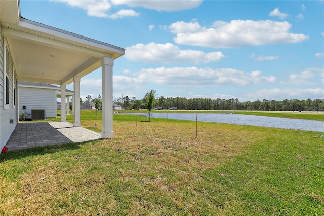 view of yard featuring central AC, a water view, and a patio