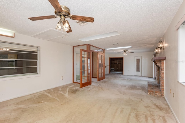 carpeted empty room featuring ceiling fan, a fireplace, and a textured ceiling