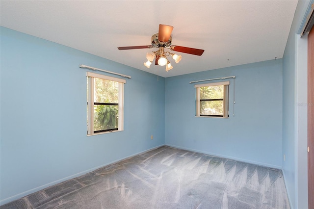 spare room with ceiling fan, plenty of natural light, and carpet flooring