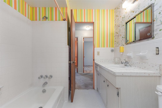 bathroom with tile patterned floors, vanity, tile walls, and a tub