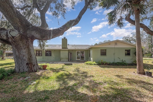 rear view of house with a yard and a patio area