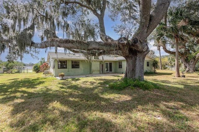 back of house with a patio and a lawn