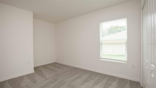 unfurnished room featuring light colored carpet