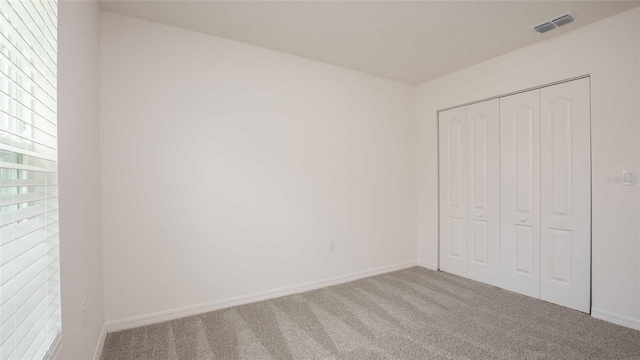 unfurnished bedroom with carpet floors and a closet