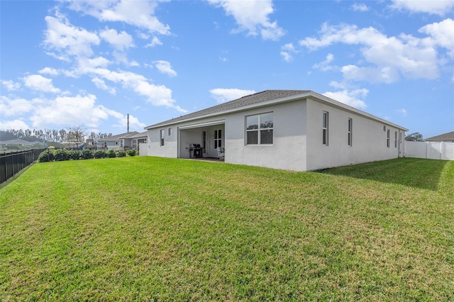 rear view of property featuring a lawn