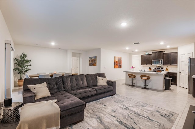 living room featuring light tile patterned floors, baseboards, visible vents, and recessed lighting