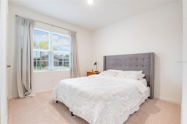 bedroom with light carpet and baseboards