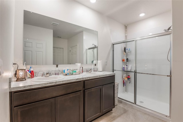 bathroom with a sink, a shower stall, and double vanity